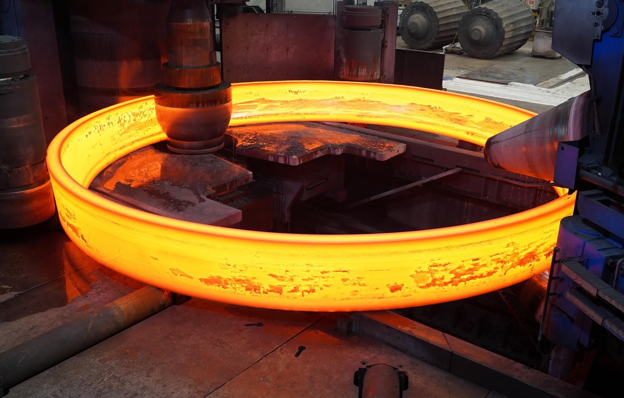 [Image: 现代化锻造车间内，巨型红炽环件轧制场景，画面清晰震撼]